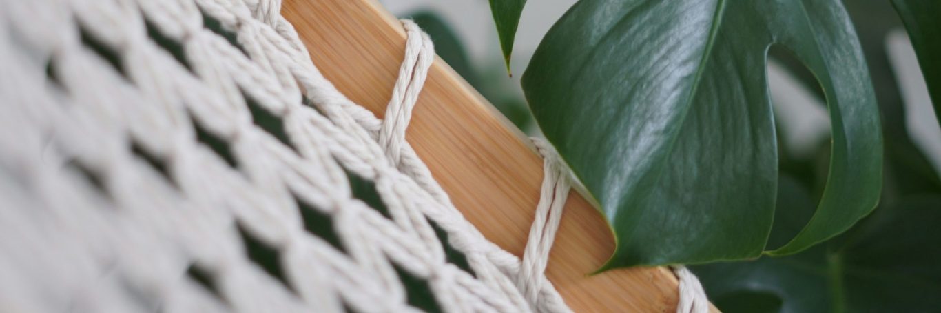 Corde tressé blanc avec une bordure en bois et une feuille verte en arrière-plan.